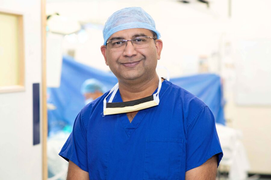 Vipul is wearing blue scrubs in a theatre