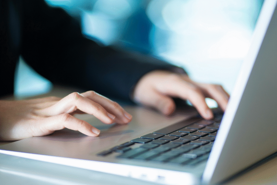 A picture of hands typing on a laptop keyboard
