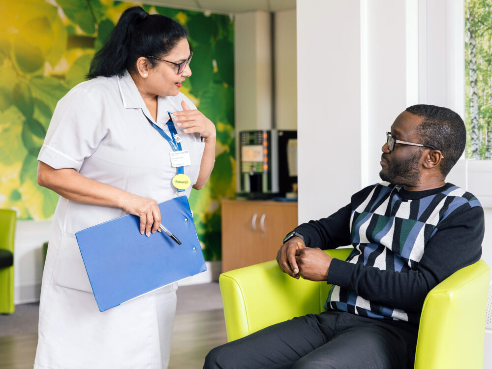 A Research Healthcare Assistant (HCA) talking to a participant at the CRDC.